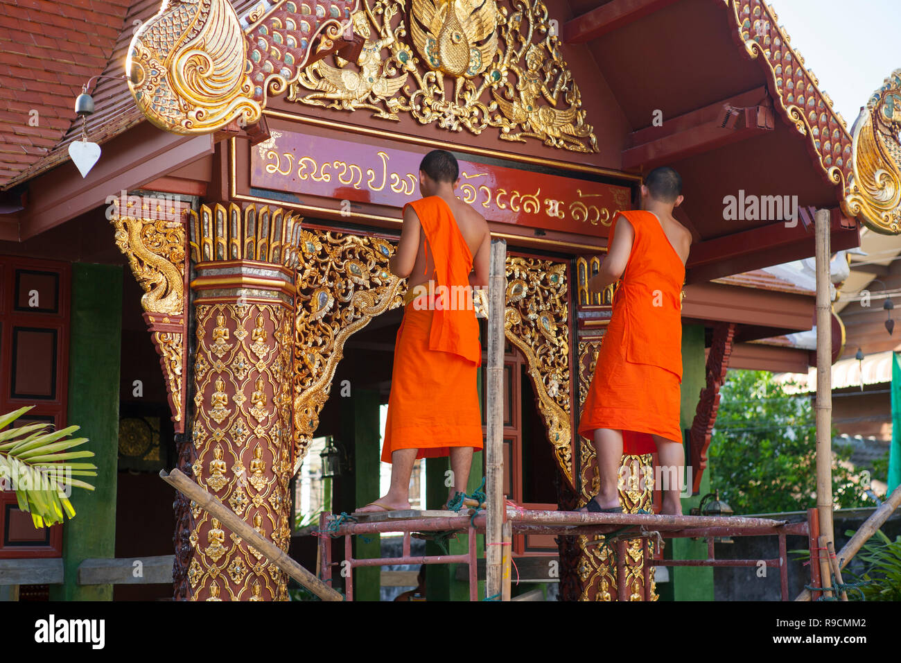 Buddhist monks cleaning a temple, Run Mueang Road, Chiang Mai, Thailand Stock Photo