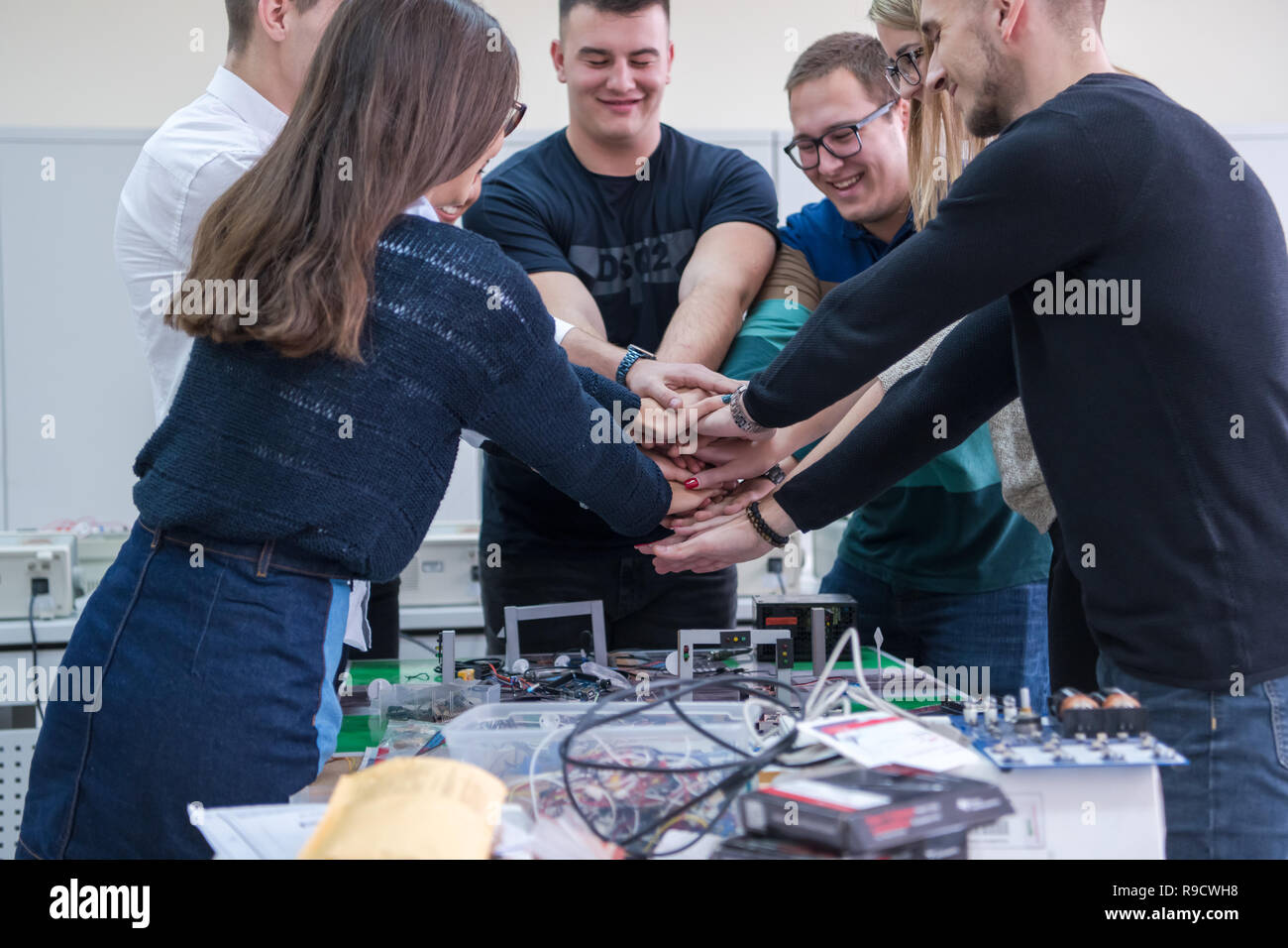 Group of young students in electronics classroom celebrating ...