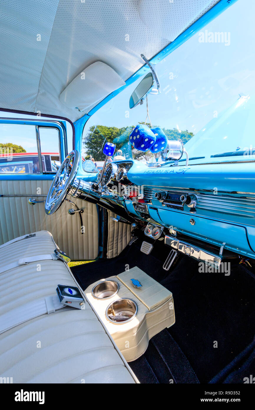 1957 Chevrolet Bel Air car. Interior by front passenger seat, fluffy dice hanging from mirror, light blue dashboard, sign, 'Heaven is a 57'. Stock Photo