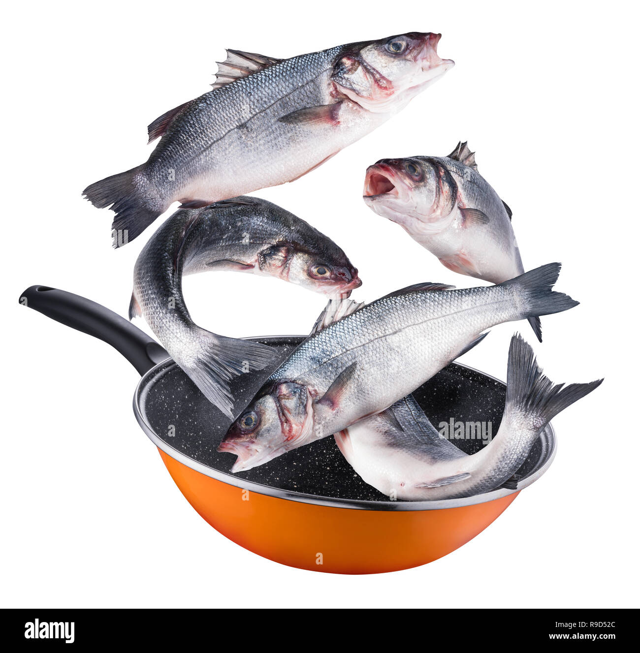 Flying seabass fishes falling into a frying pan. Flying motion effect of cooking process. File contains clipping path. Stock Photo