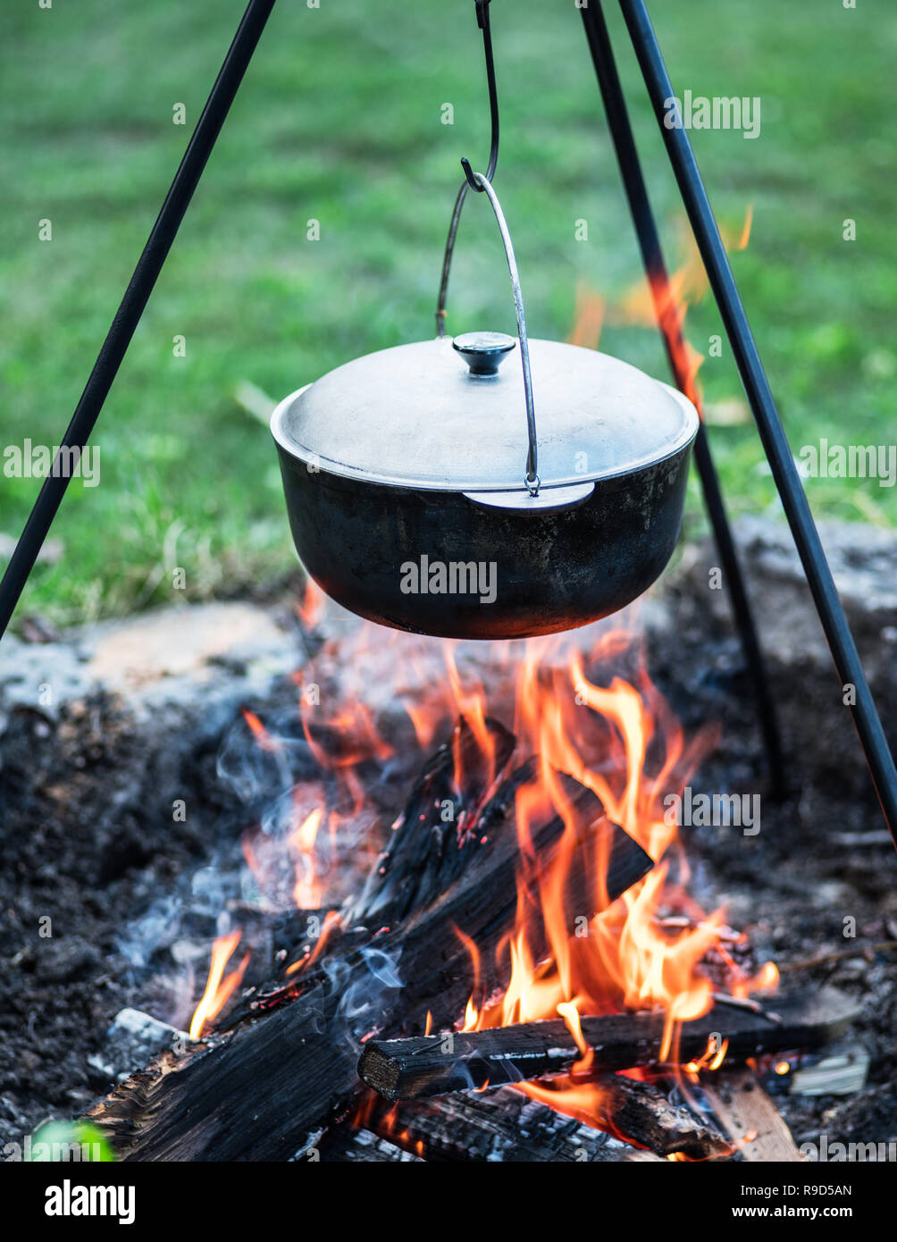 Cooking in the open-air. Cauldron over the campfire. Stock Photo