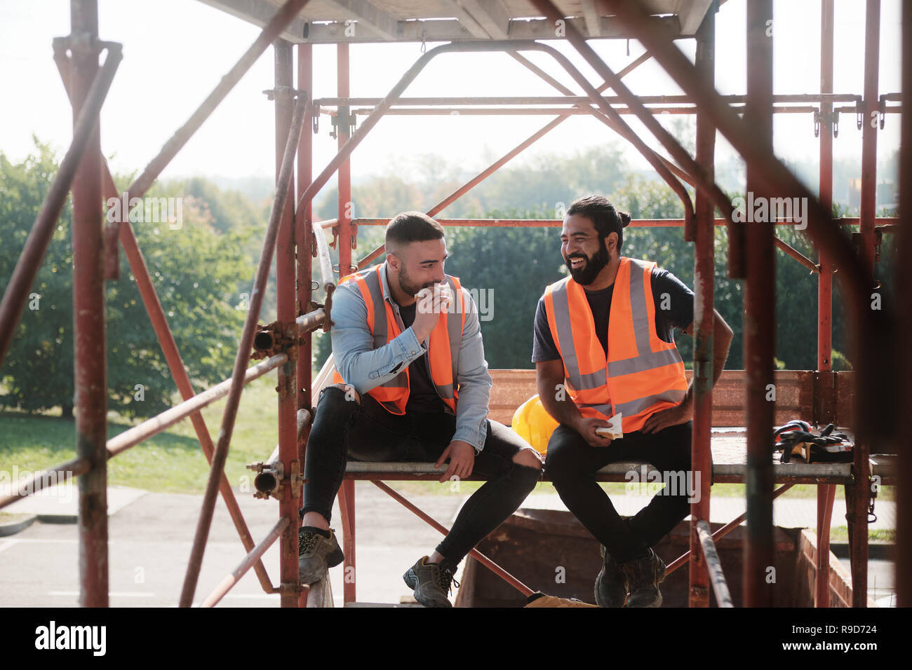 Happy Workers In Construction Site During Lunch Break Stock Photo