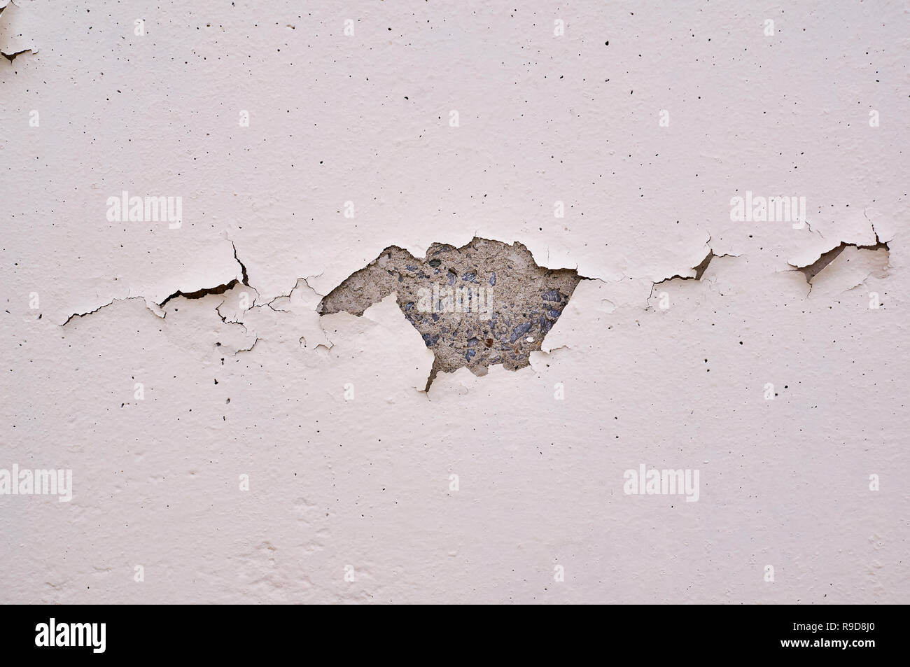 Painted beige wall with cracks and chipped. Stock Photo