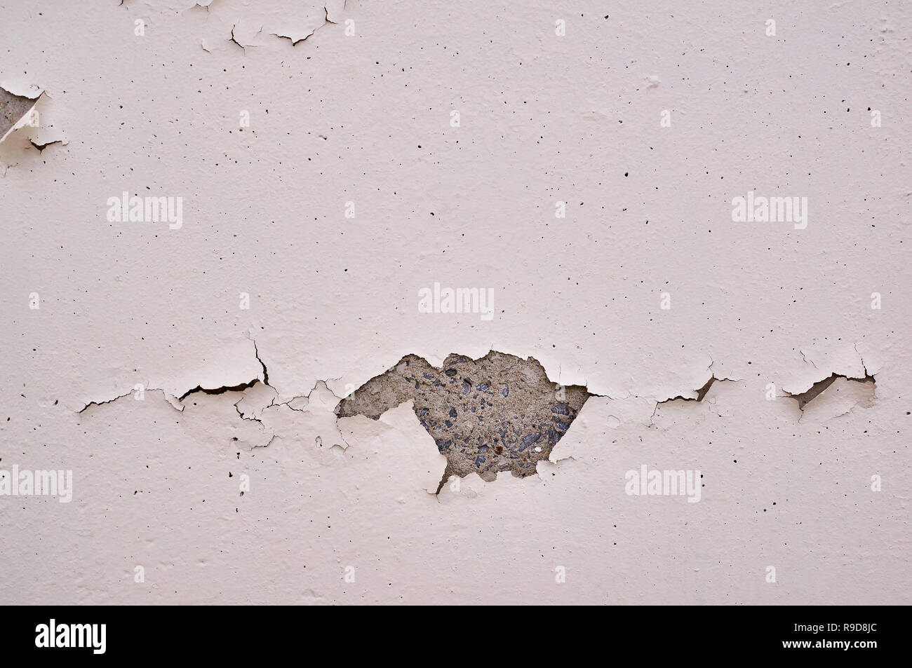Painted beige wall with cracks and chipped. Stock Photo