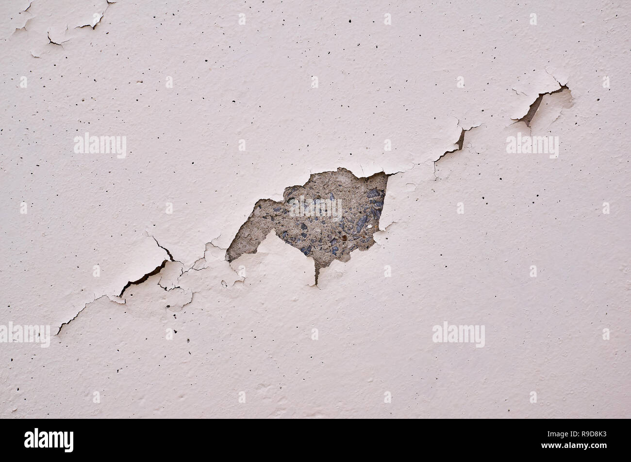 Painted beige wall with cracks and chipped. Stock Photo