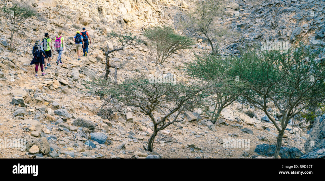 Ras Al Khaimah, UAE, January 13, 2017: A group of hikers on a trail in Hajar mountains in Ras Al Khaimah, UAE Stock Photo