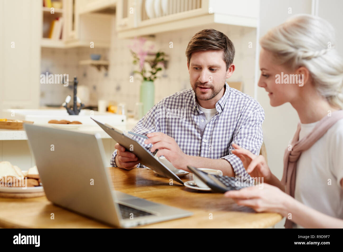 Young couple discussing finances at kitchen Stock Photo