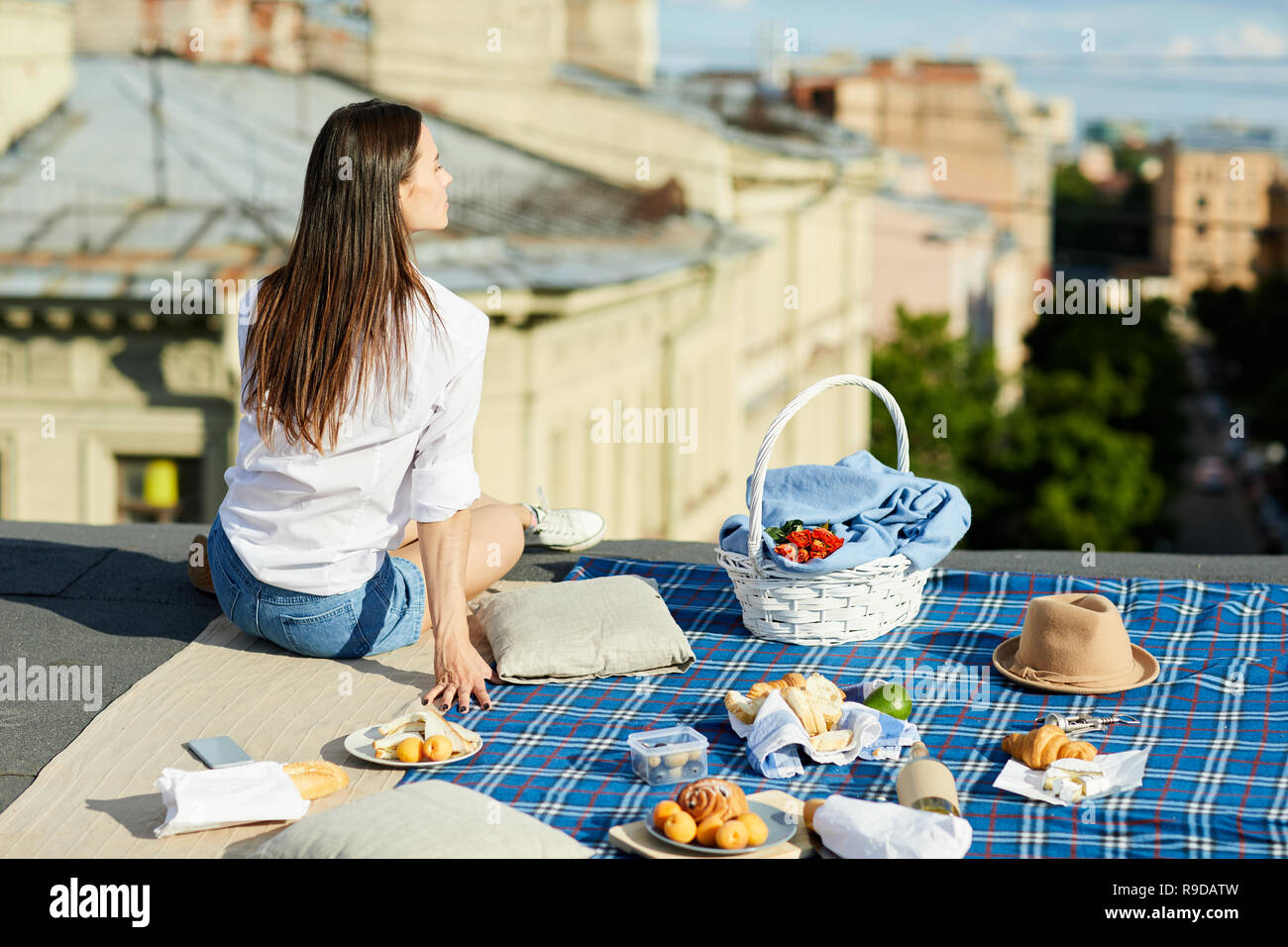 Dreamy girl having lunch on roof Stock Photo - Alamy