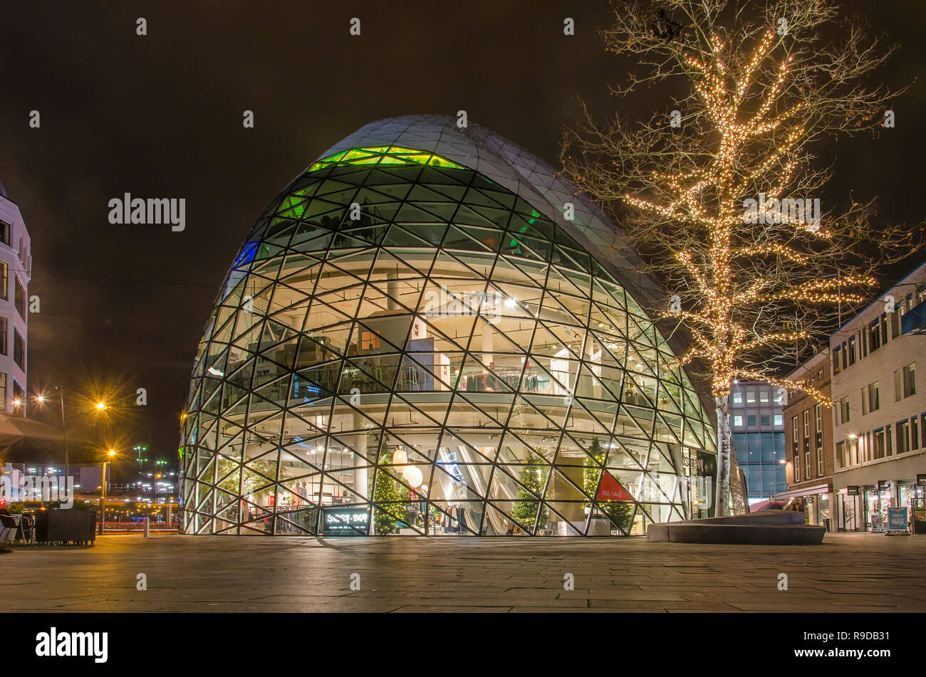 Eindhoven, The Netherlands, December 14, 2018: Glass dome-shaped clothing store and tree with Christmas decorations on Emmasingel at night Stock Photo