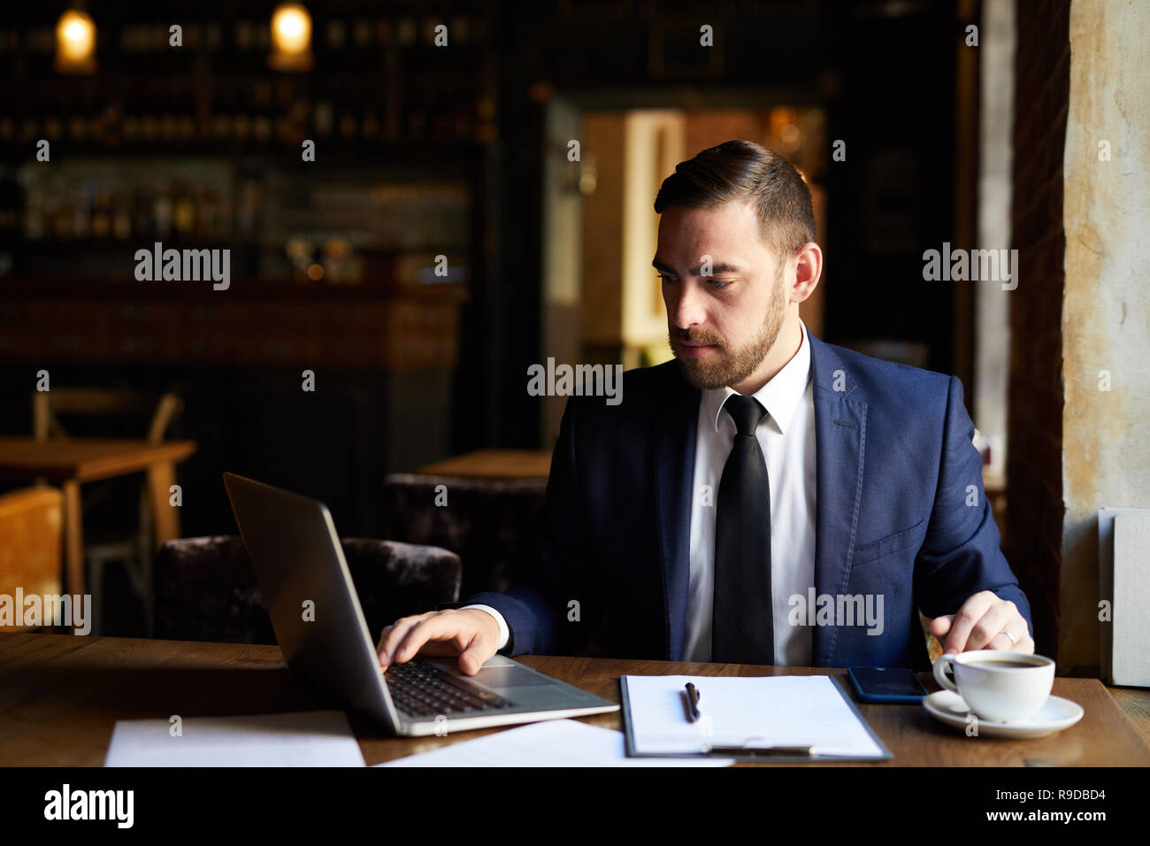 Busy man using laptop in cafe Stock Photo