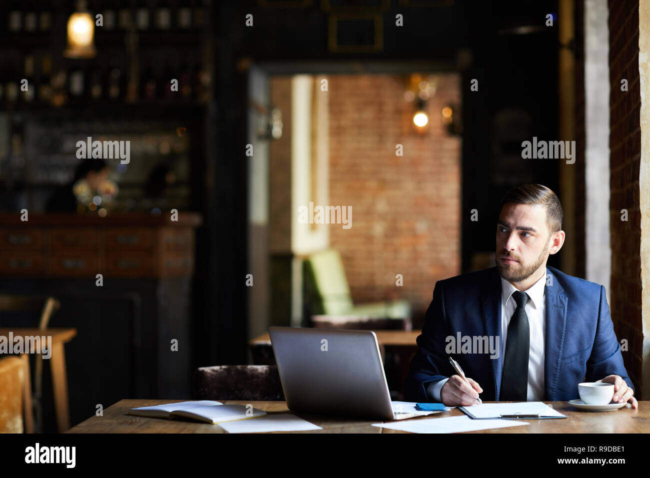 Businessman making notes in report Stock Photo