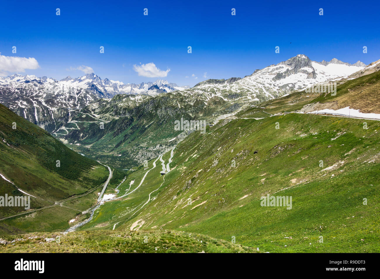 Summer landscape from Furka pass with the serpentine road climbing up the Rhone Valley and the Rhone Glacier on the right, Valais, Switzerland Stock Photo