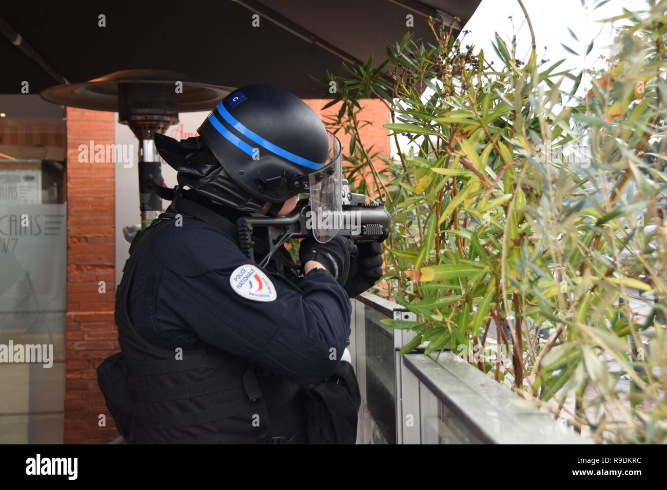 Toulouse, France. 22nd December 2018. Serious clashes occured on December the 22nd in the streets of Toulouse, France, between riot police units (CRS) and the yellow vest (gilets jaunes). Police largely used tear gas. Such violences occured all over France. A policemen is firing with a flash ball rifle. Credit: larouteaulongcours.fr/Alamy Live News Stock Photo