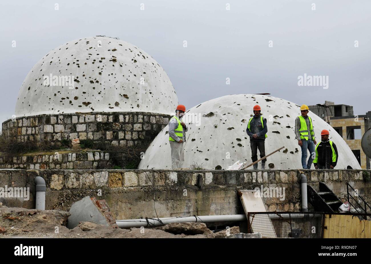 Aleppo, Syria. 22nd Dec, 2018. Syrian workers stand on the rooftop of the covered Souk al-Saqatiyya in Aleppo, northern Syria, on Dec. 19, 2018. In Syria's northern Aleppo city, the determination of the residents to rebuild their lives and city is stronger than the massive destruction that has befallen them. Two years since its liberation, people have already rolled up their sleeves and started fixing the destruction in the ancient walled marketplace in the city, not discouraged by the devastation. Credit: Ammar Safarjalani/Xinhua/Alamy Live News Stock Photo