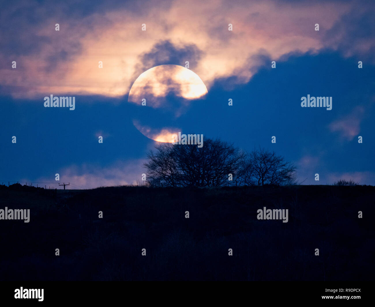 Wirksworth, UK. 22nd Dec, 2018. UK Weather: Winter Solstice Full Moon rising in between the clouds over Cromford Moor, Bolehill taken from the StarDisc above Wirksworth in the Derbyshire Dales Credit: Doug Blane/Alamy Live News Stock Photo