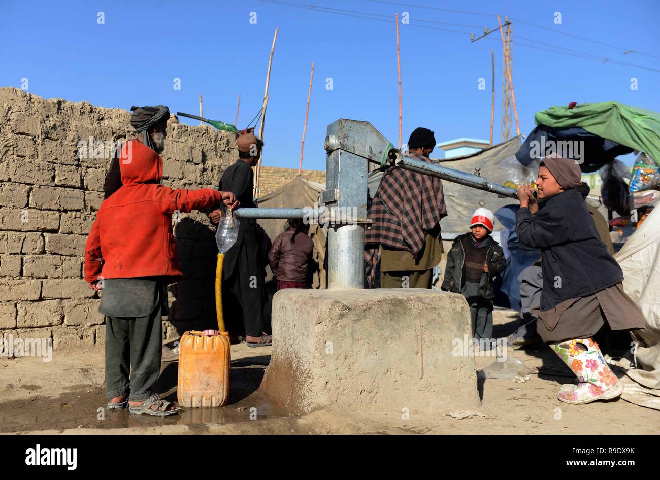 Kandahar, Afghanistan. 22nd Dec, 2018. An Afghan child pumps water from a ground well at an internally displaced persons (IDPs) camp in Kandahar province, southern Afghanistan, Dec. 22, 2018. Thousands of Afghans have left their houses following critical draught, growing insecurity and Taliban-led insurgency in southern Afghan provinces, where officials warned a human tragedy if continued. Credit: Sanaullah Seiam/Xinhua/Alamy Live News Stock Photo