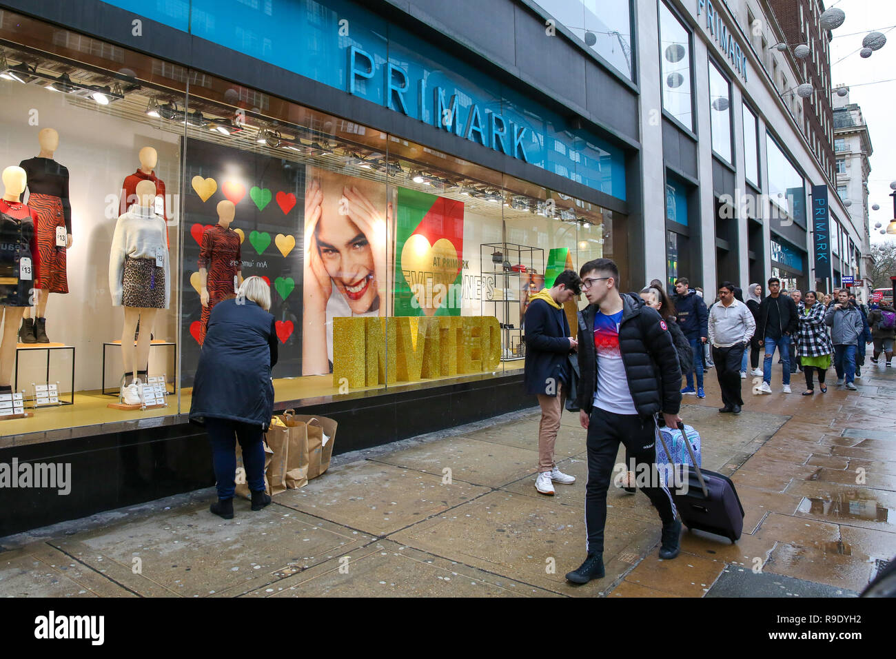 Shoppers are seen walking past H&M window display with a large SALE sign.  Last minute Christmas shoppers take advantage of pre-Christmas bargains at  Oxford Street in London. Fewer shoppers have been reported