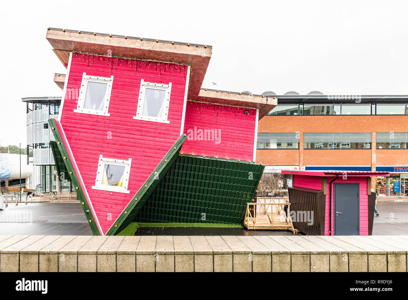 Bournemouth, UK. 23rd Dec, 2018. The upside-down house in The Triangle area of Bournemouth attracts shoppers just before Christmas. Visitors can enter the attraction for a new perspective on the world. Credit: Thomas Faull/Alamy Live News Stock Photo