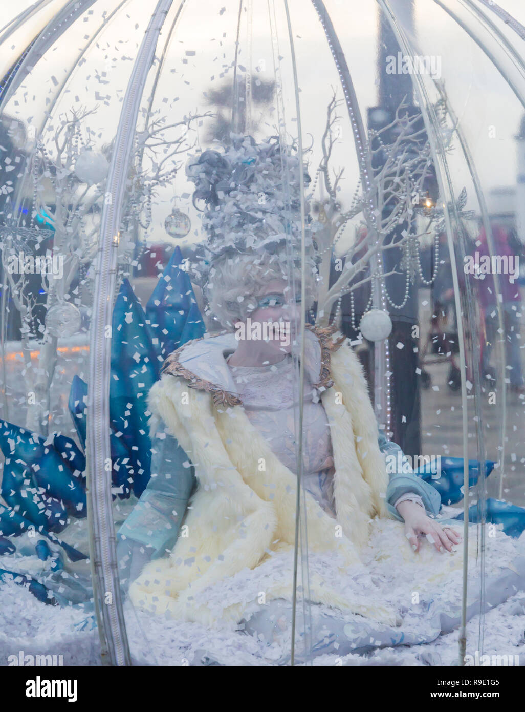 Bournemouth,  UK. 23rd December 2018. Children are fascinated by the human snowglobe with the beautiful snow queen encased in her snow blizzard, as she gracefully glides along enchanting visitors young and old. Credit: Carolyn Jenkins/Alamy Live News Stock Photo