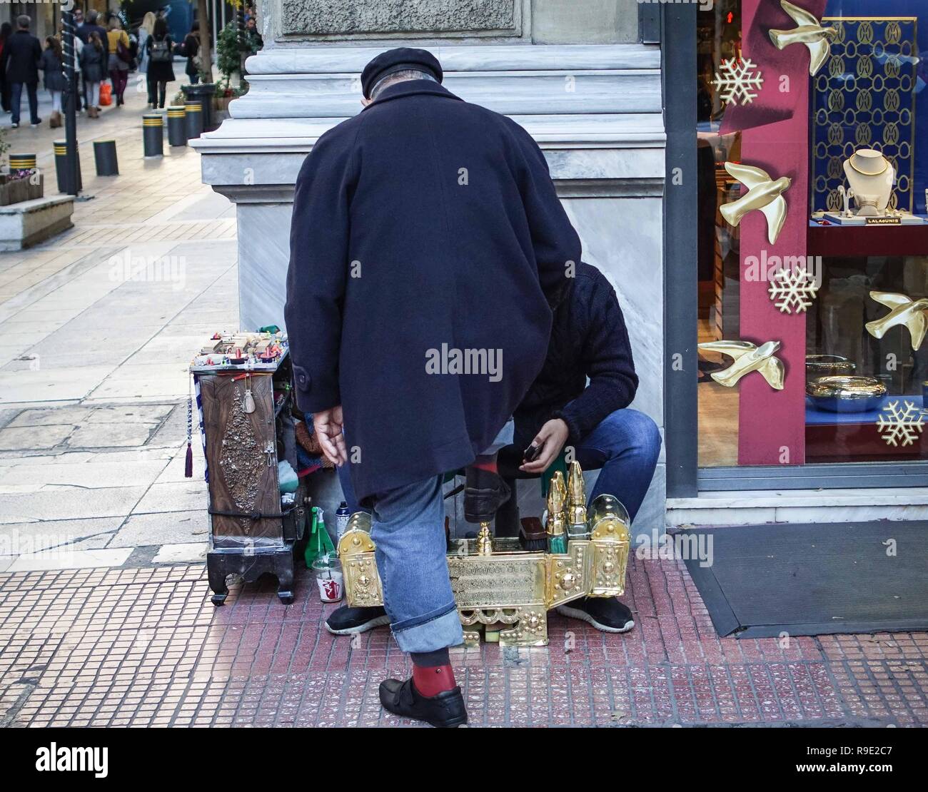 Athens, Greece. 23rd Dec, 2018. A street vendor seen brushing the shoes of  a man in Central Athens. Credit: Ioannis Alexopoulos/SOPA Images/ZUMA  Wire/Alamy Live News Stock Photo - Alamy