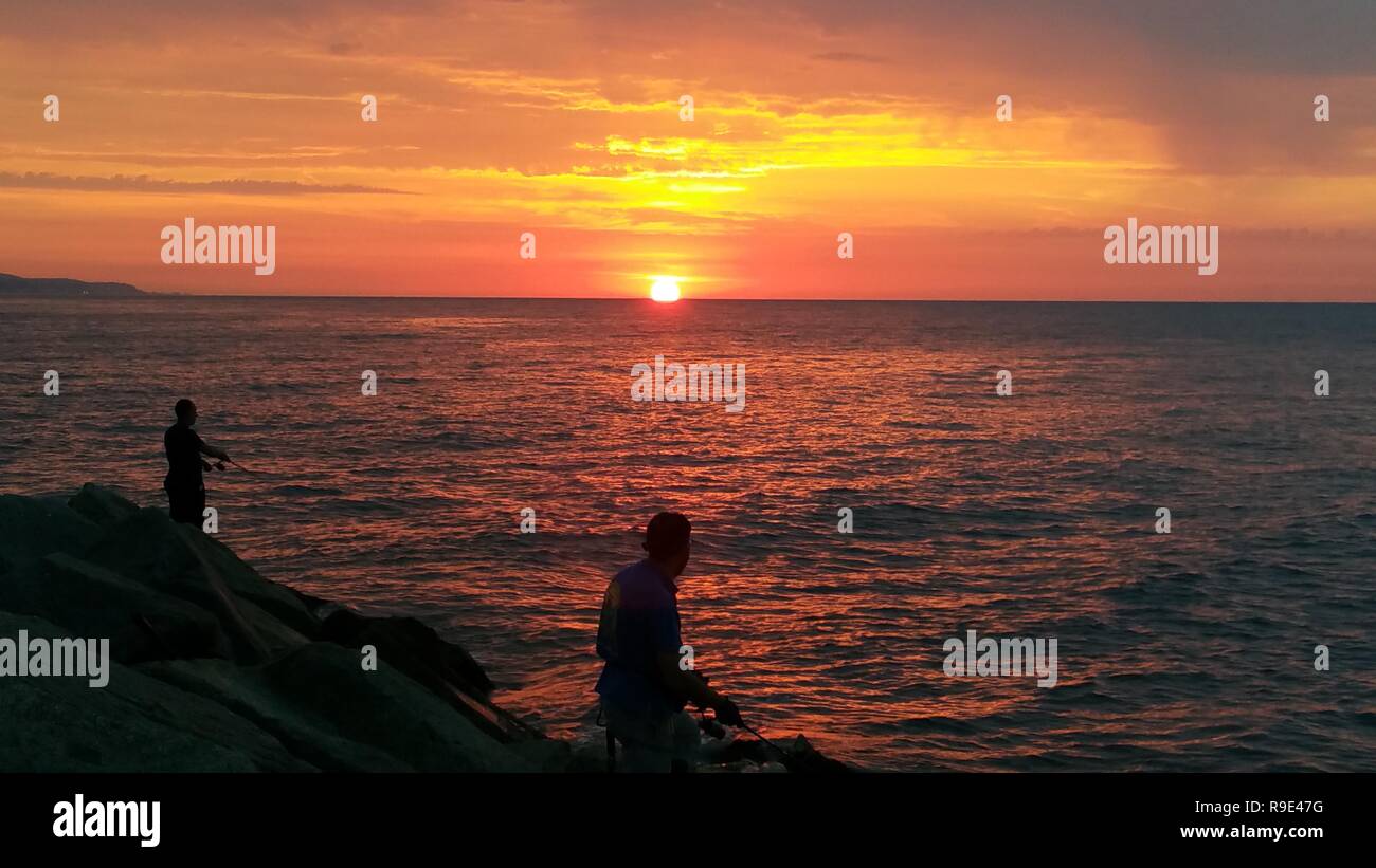 Two fishermen looking sunrise Stock Photo