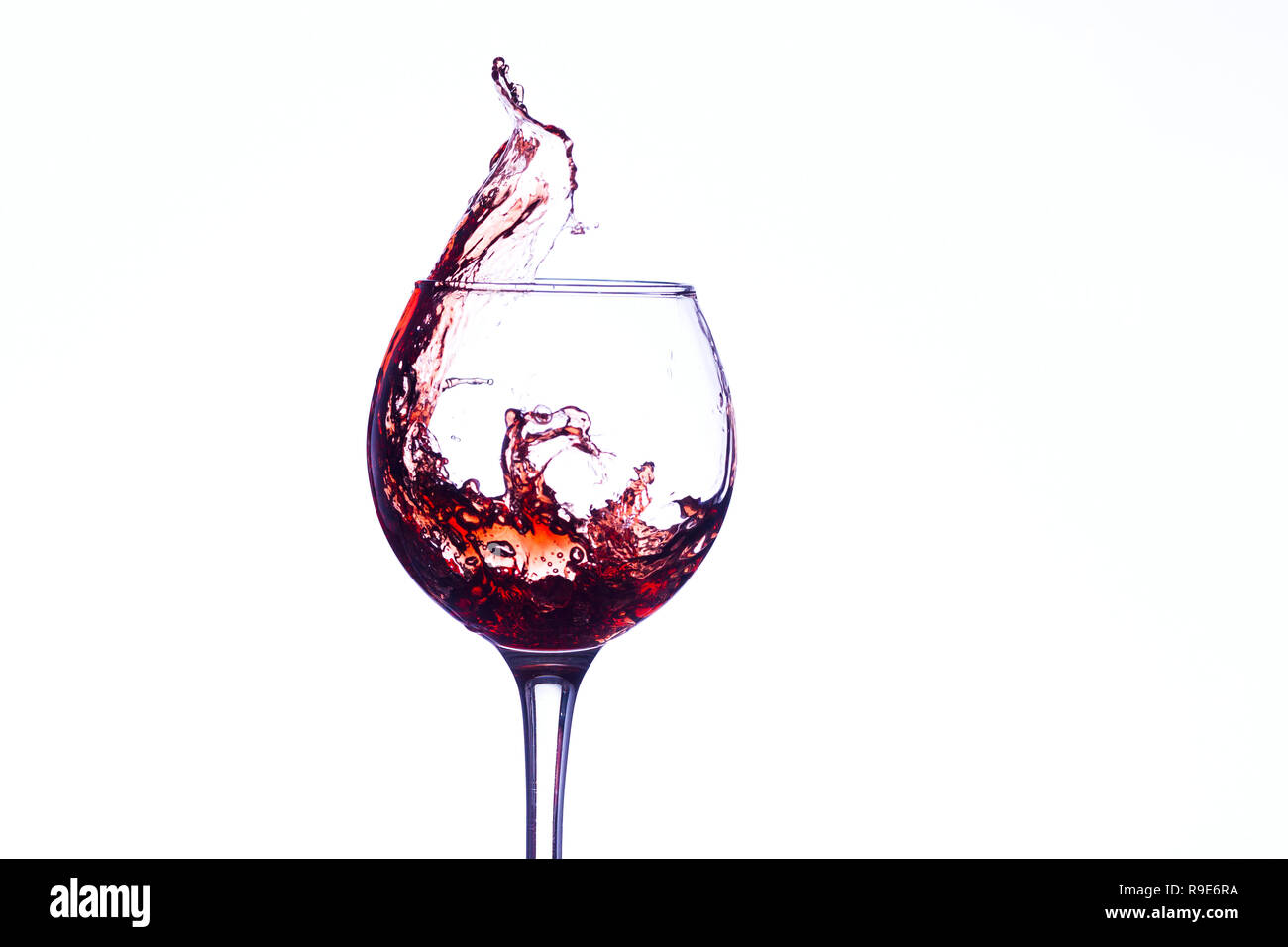 Wine splashing in glass, acrylic background, studio lighting Stock Photo