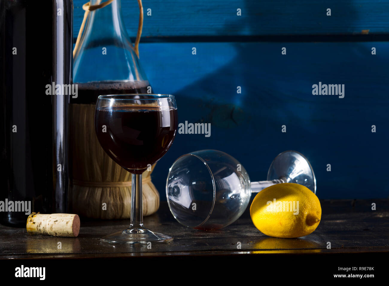 Wine, lemon, wine glasses on a wooden background, studio lighting Stock