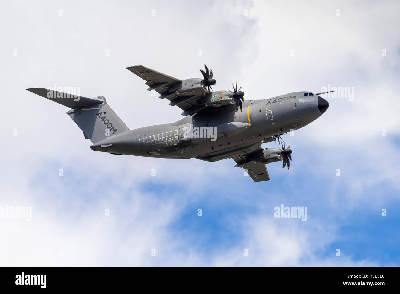 Airbus A400M Atlas military transport aircraft performs a clean pass (wheels up), flying overhead from left to right. Stock Photo