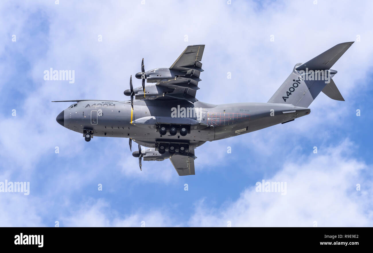 Airbus A400M Atlas military transport aircraft performs a dirty pass (wheels down), flying overhead from right to left. Stock Photo