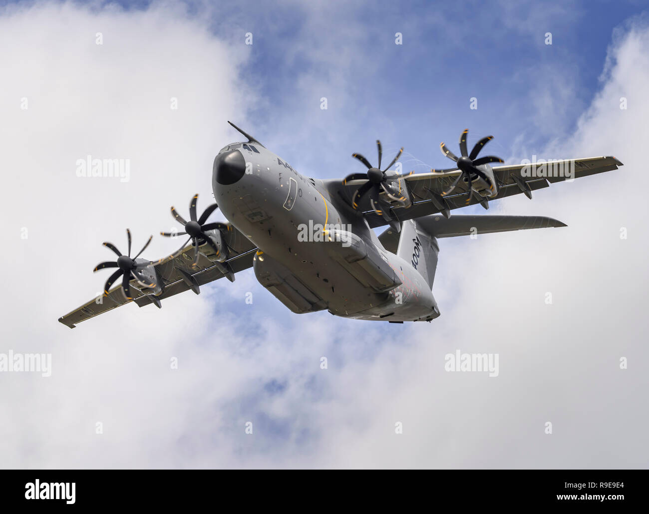 Airbus A400M Atlas military transport aircraft performs a clean pass (wheels up), flying overhead from right to left. Stock Photo