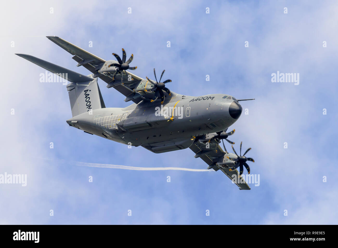 Airbus A400M Atlas military transport aircraft performs a clean pass (wheels up), flying overhead from left to right. Stock Photo