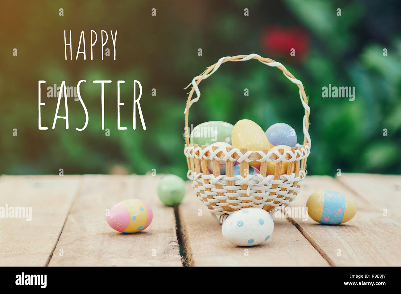 Colorful easter eggs in basket on wooden table background Stock Photo