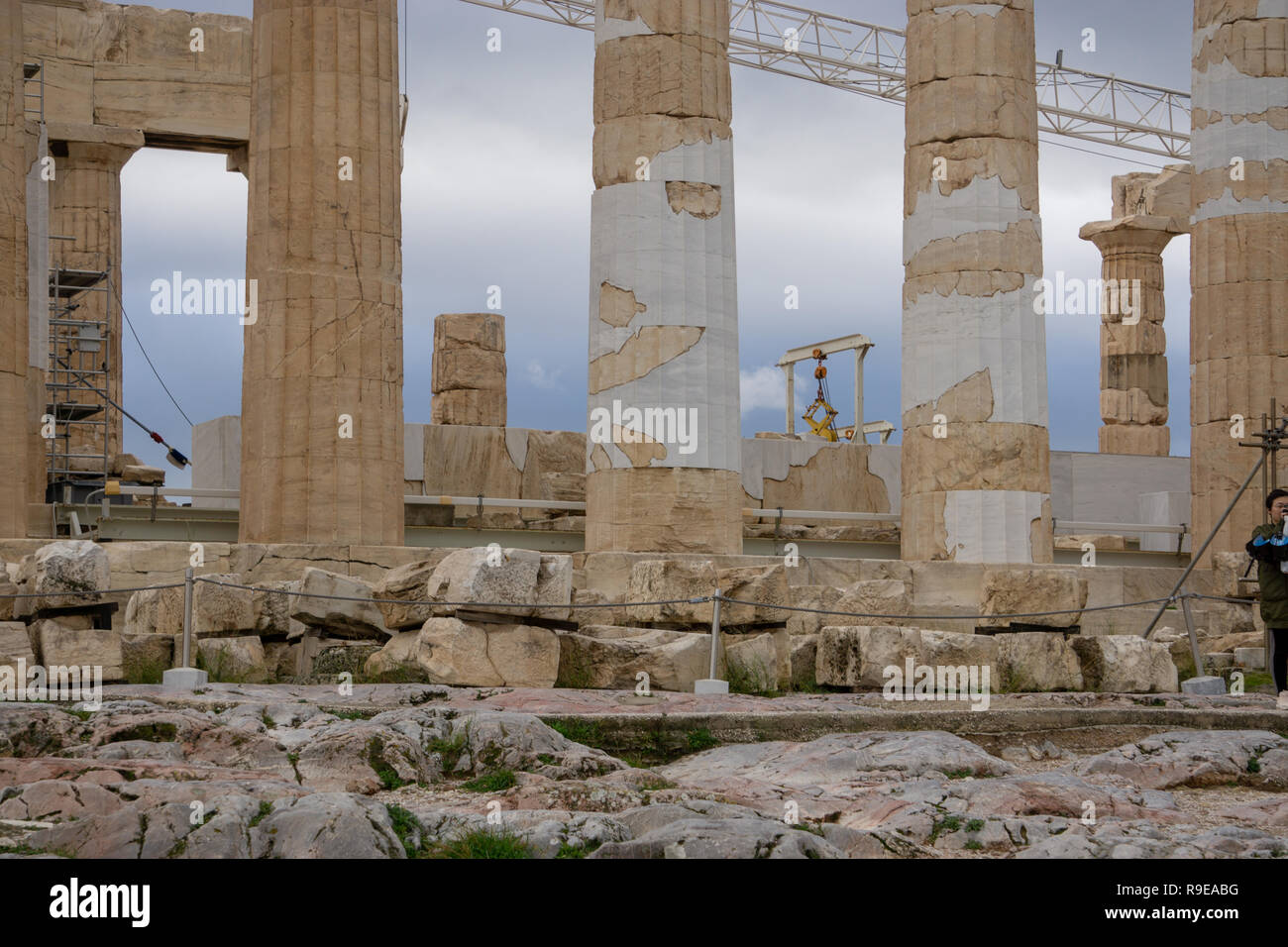 It is amazing to see how fragile our modern construction equipment  looks in comparison to the magnificent columns of Parthenon. Stock Photo