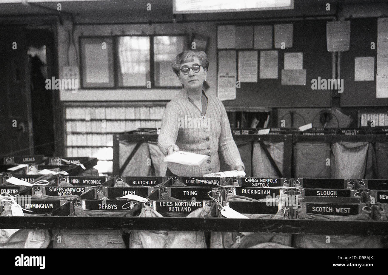 1948, inside a Royal Mail postal sorting office, picture shows a female worker putting letters into individual sacks for the different towns and regions of the UK. Stock Photo