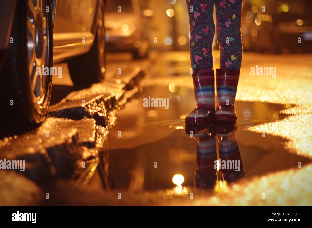 Girl in rubber boots in a puddle Stock Photo - Alamy