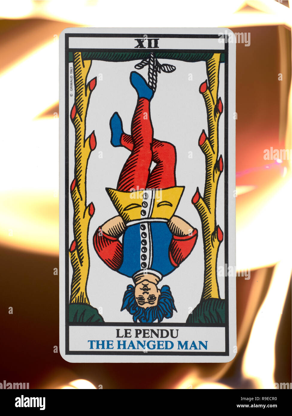 The Hanged Man, tarot card from a deck of the Tarot de Marseille, floating on a burning flame background Stock Photo