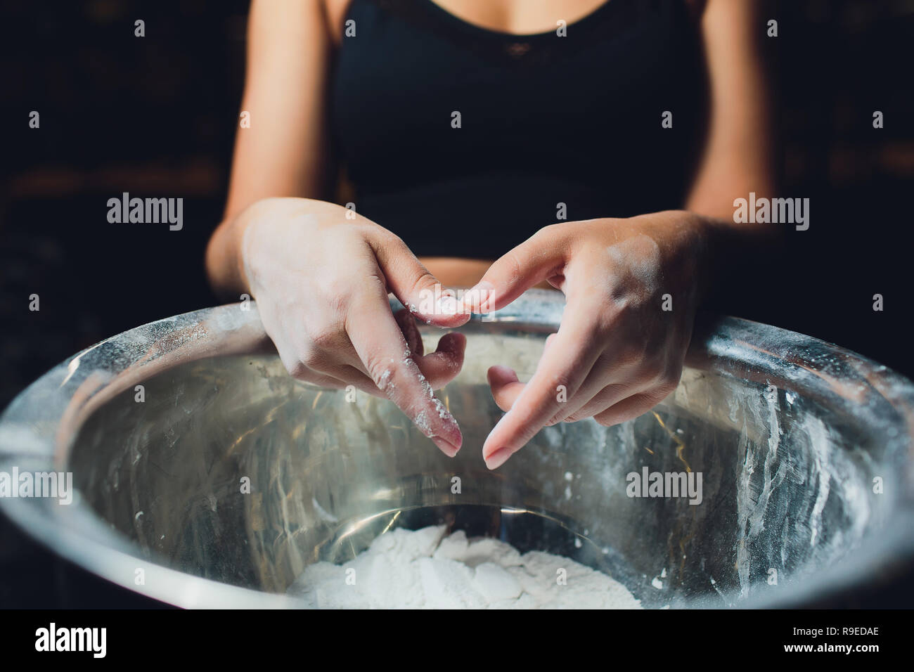 Cropped shot of young female athlete clapping hands with chalk powder