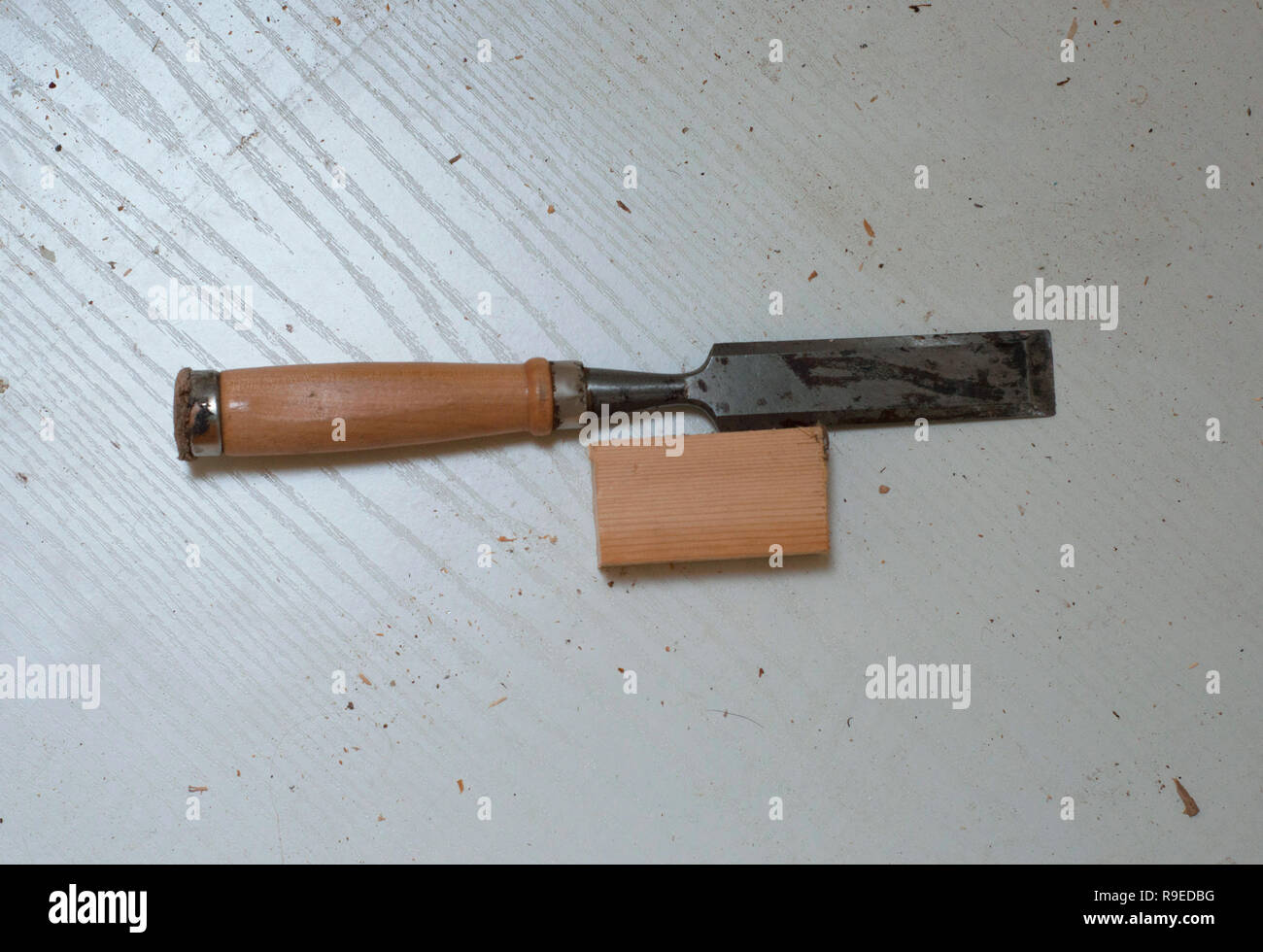 A metallic chisel with wooden handle on the laminate background. Top view of a chisel and a