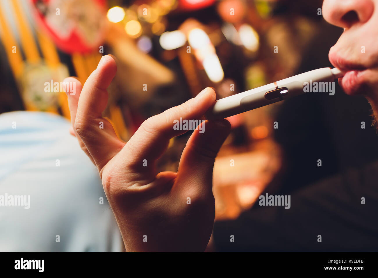 IQOS heat-not-burn tobacco product technology. Man holding e-cigarette in  his hand before smoking Stock Photo - Alamy