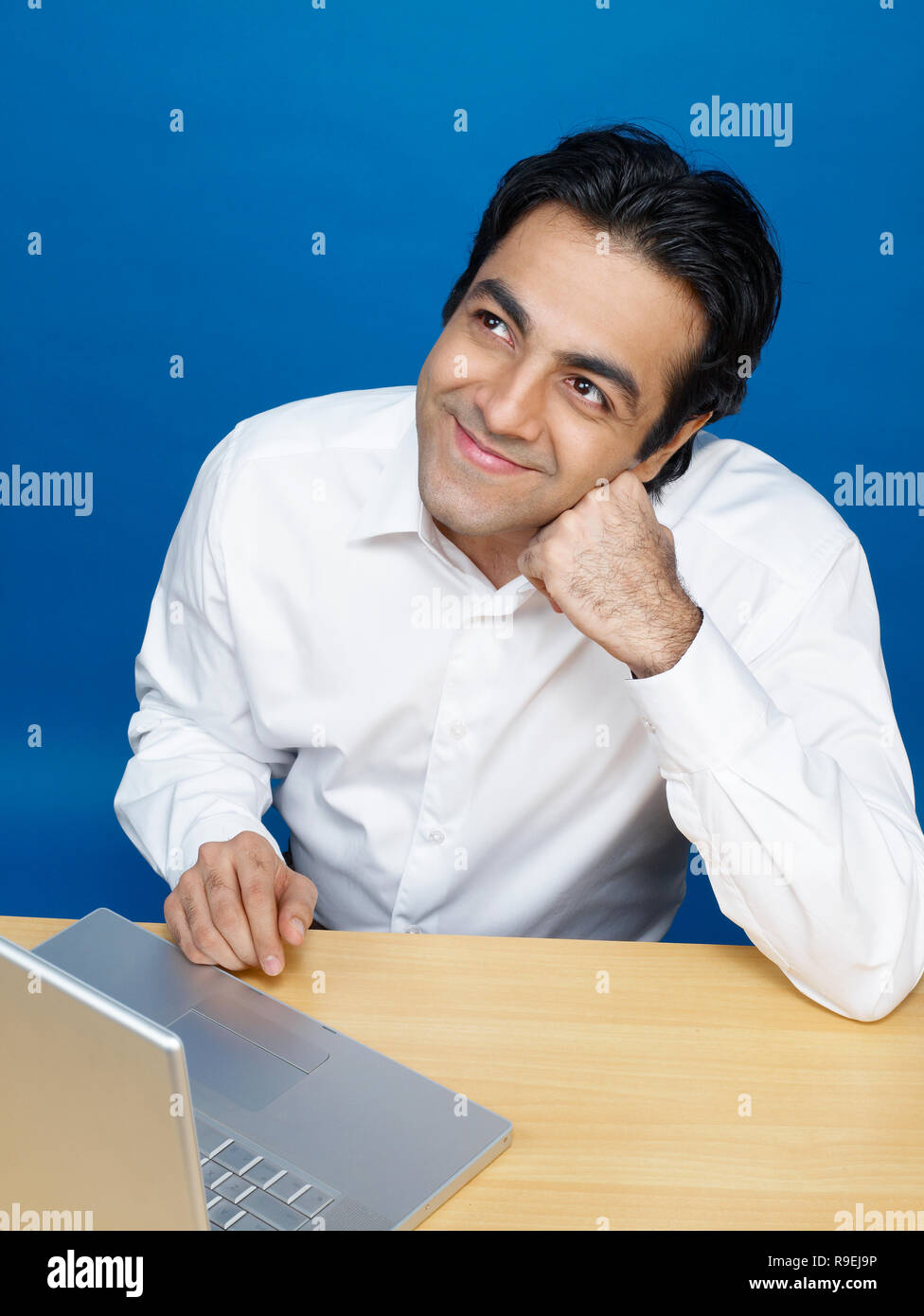 MAN WORKING ON COMPUTER IN AN OFFICE/CALL CENTRE Stock Photo