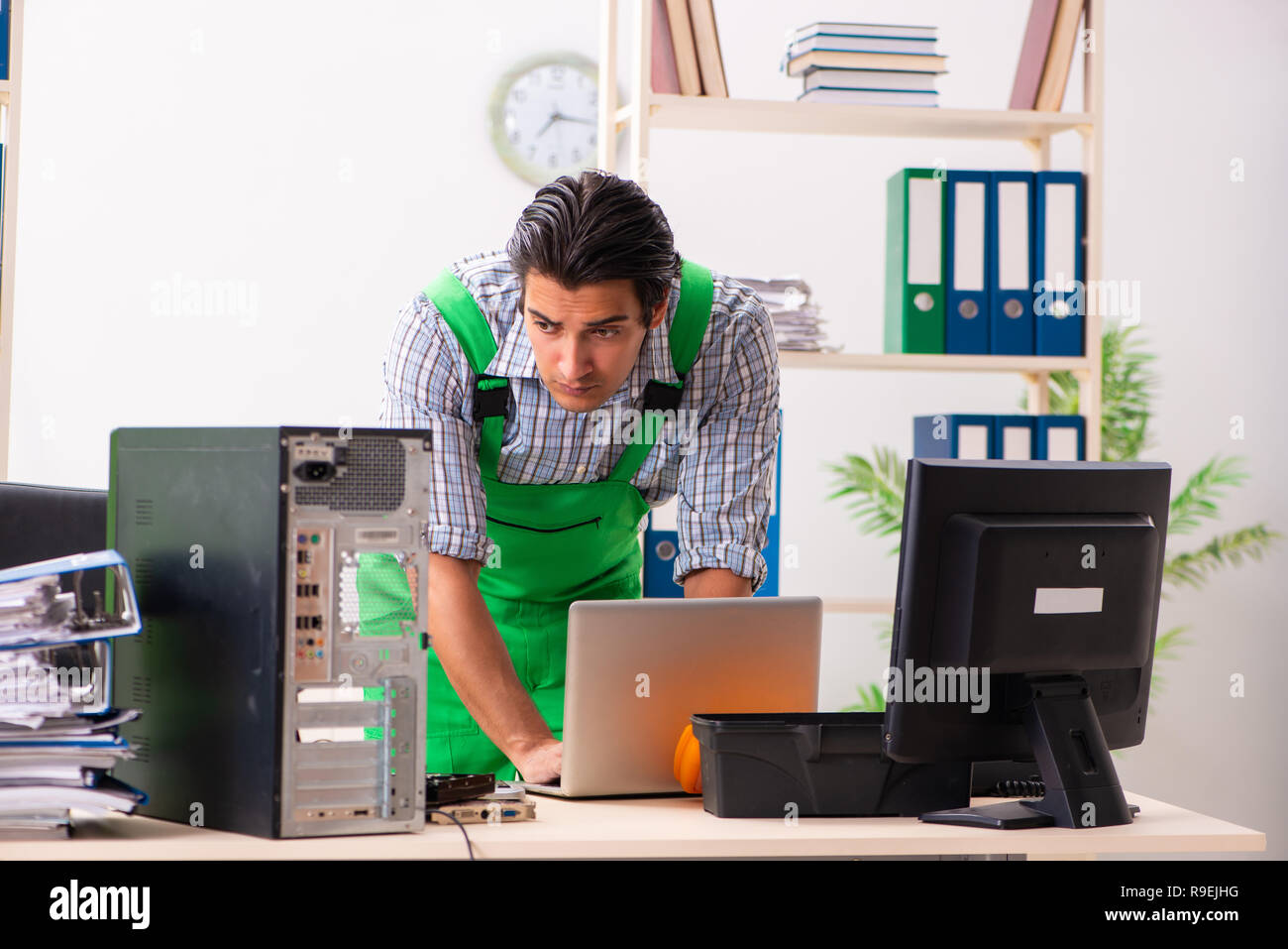 Young engineer repairing broken computer at the office Stock Photo - Alamy