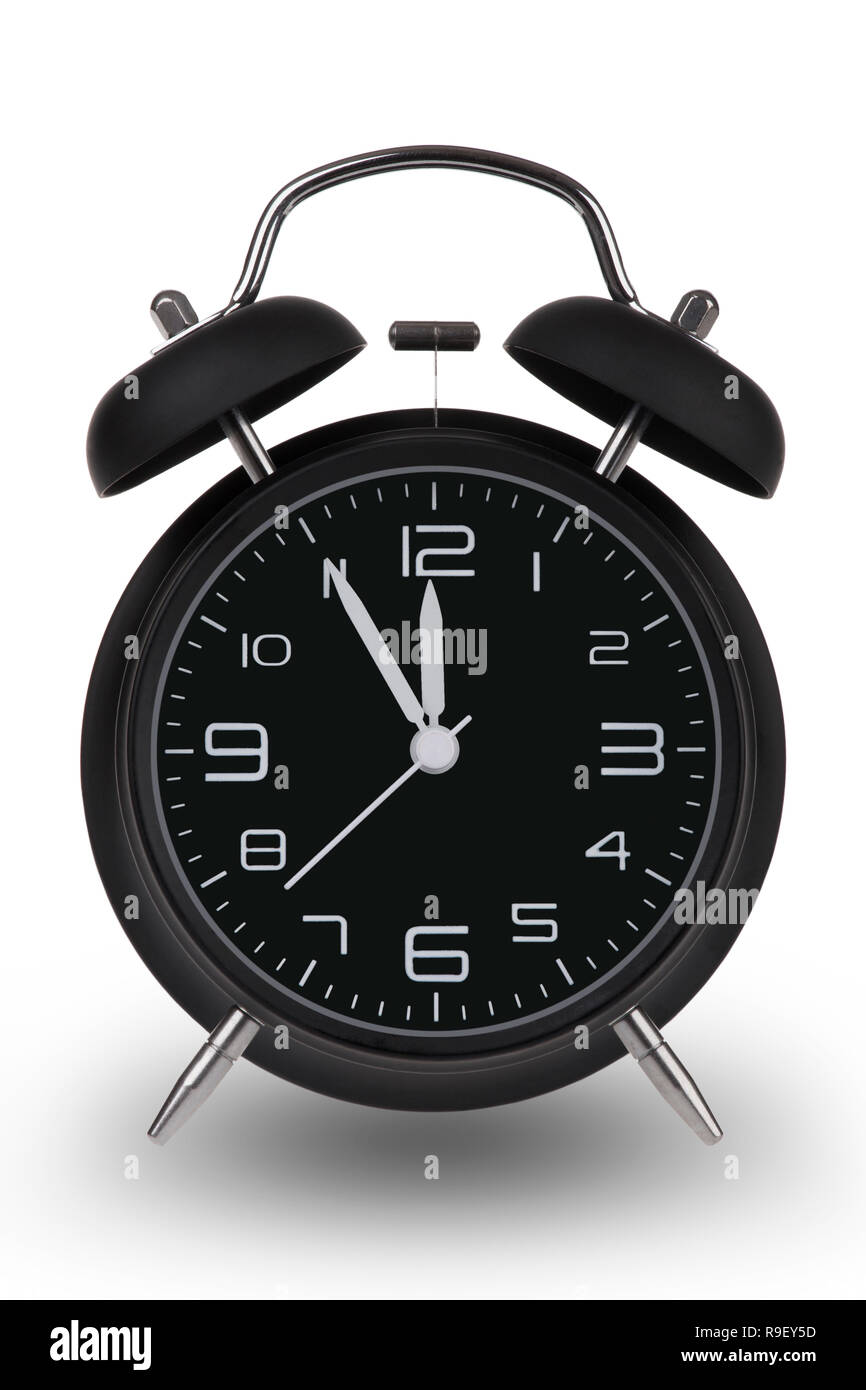 Black alarm clock with the hands at 5 minutes till 12. Illustrating Time is Running Out isolated on a white background Stock Photo