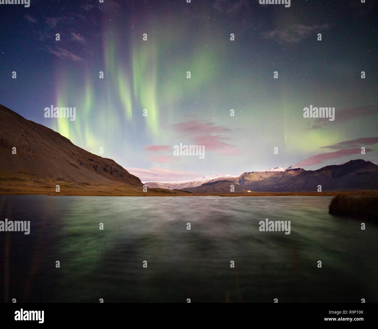 Aurora borealis northern lights over a lake Iceland pink clouds Stock ...