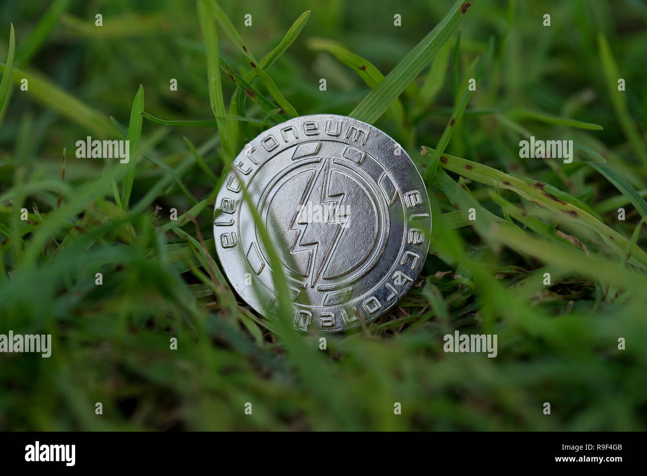 Electroneum mobile cryptocurrency physical coin placed on the grass Stock Photo