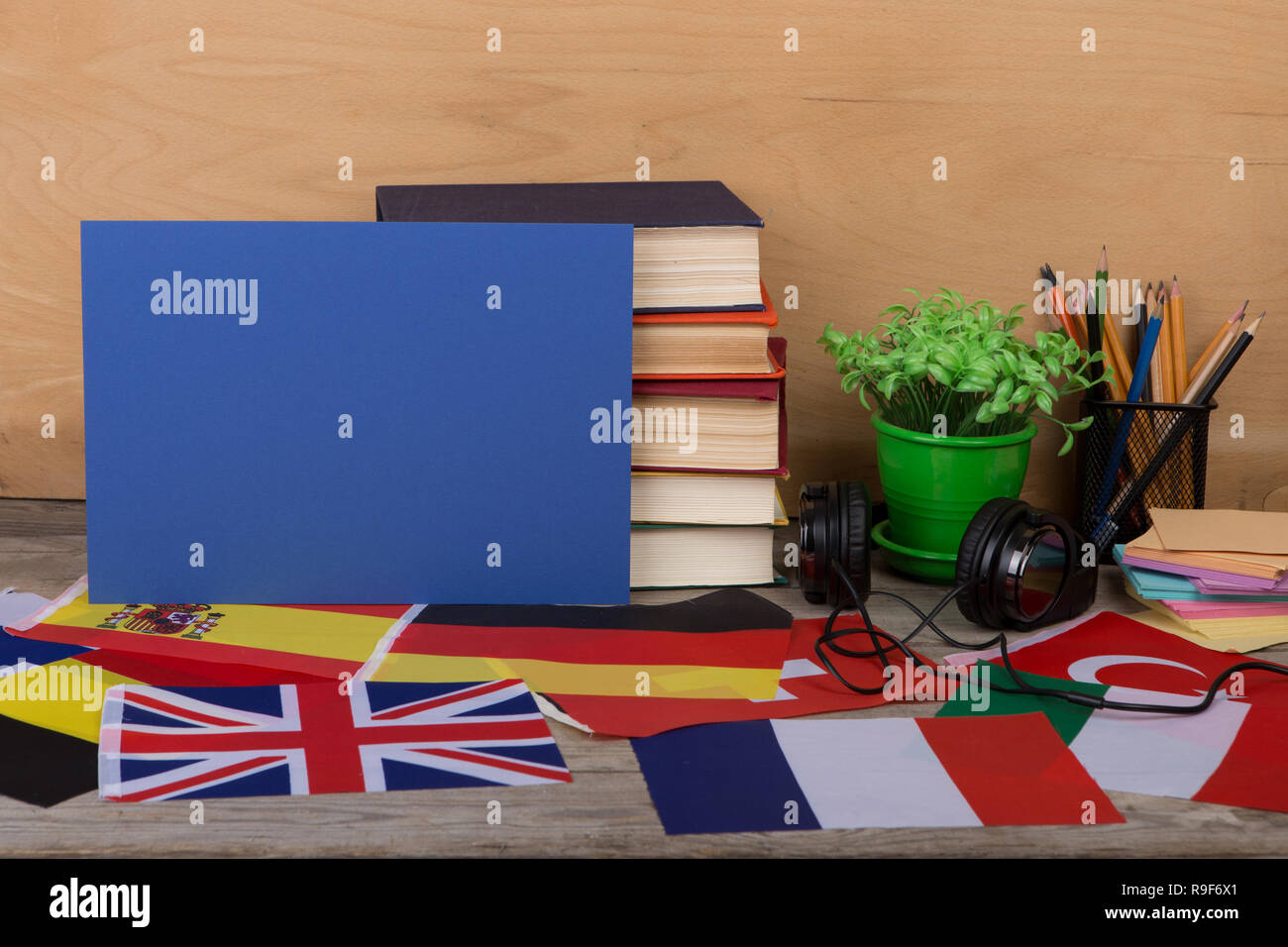 Learning languages concept - blank paper, flags, books, headphones, pencils on wooden background Stock Photo