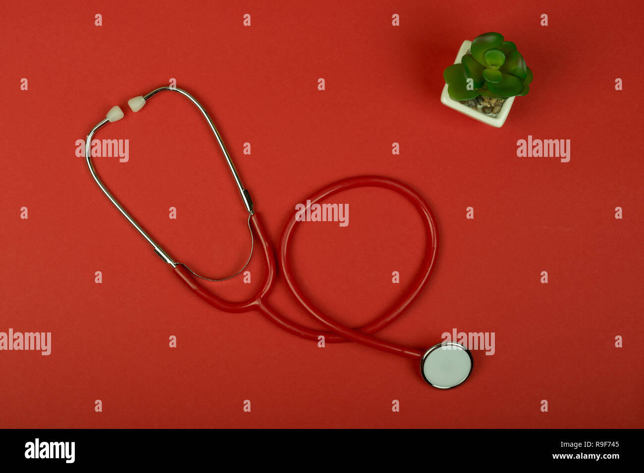 Medical concept - top view red stethoscope on red paper background Stock Photo