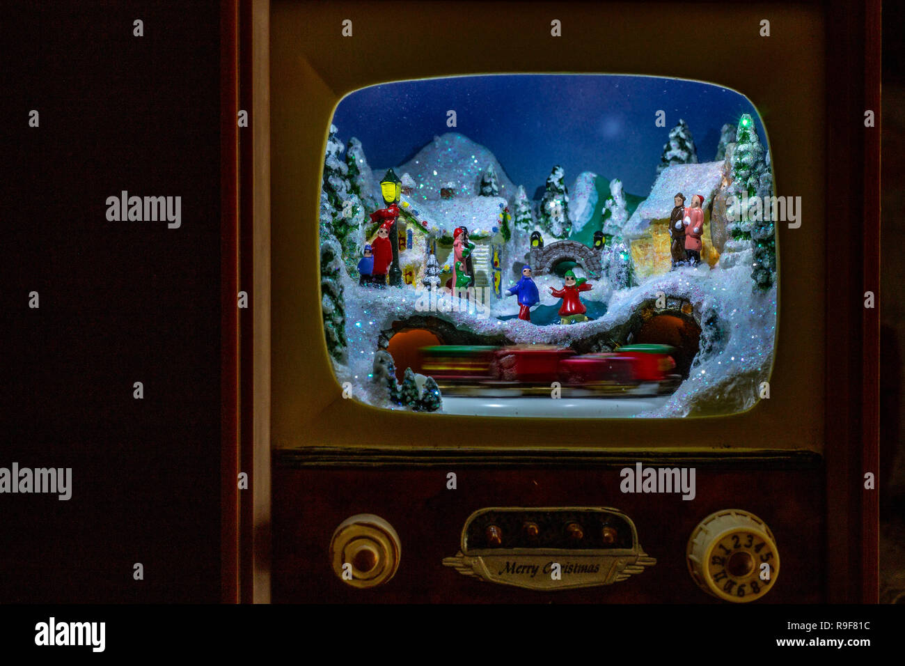 Christmas decoration. An entire village in a small antique TV, with the train and people on the streets. Stock Photo