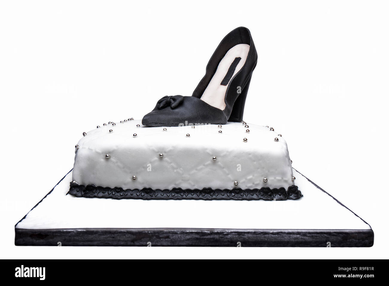 Marshmallow cake design with black woman shoe on top isolated on white Stock Photo