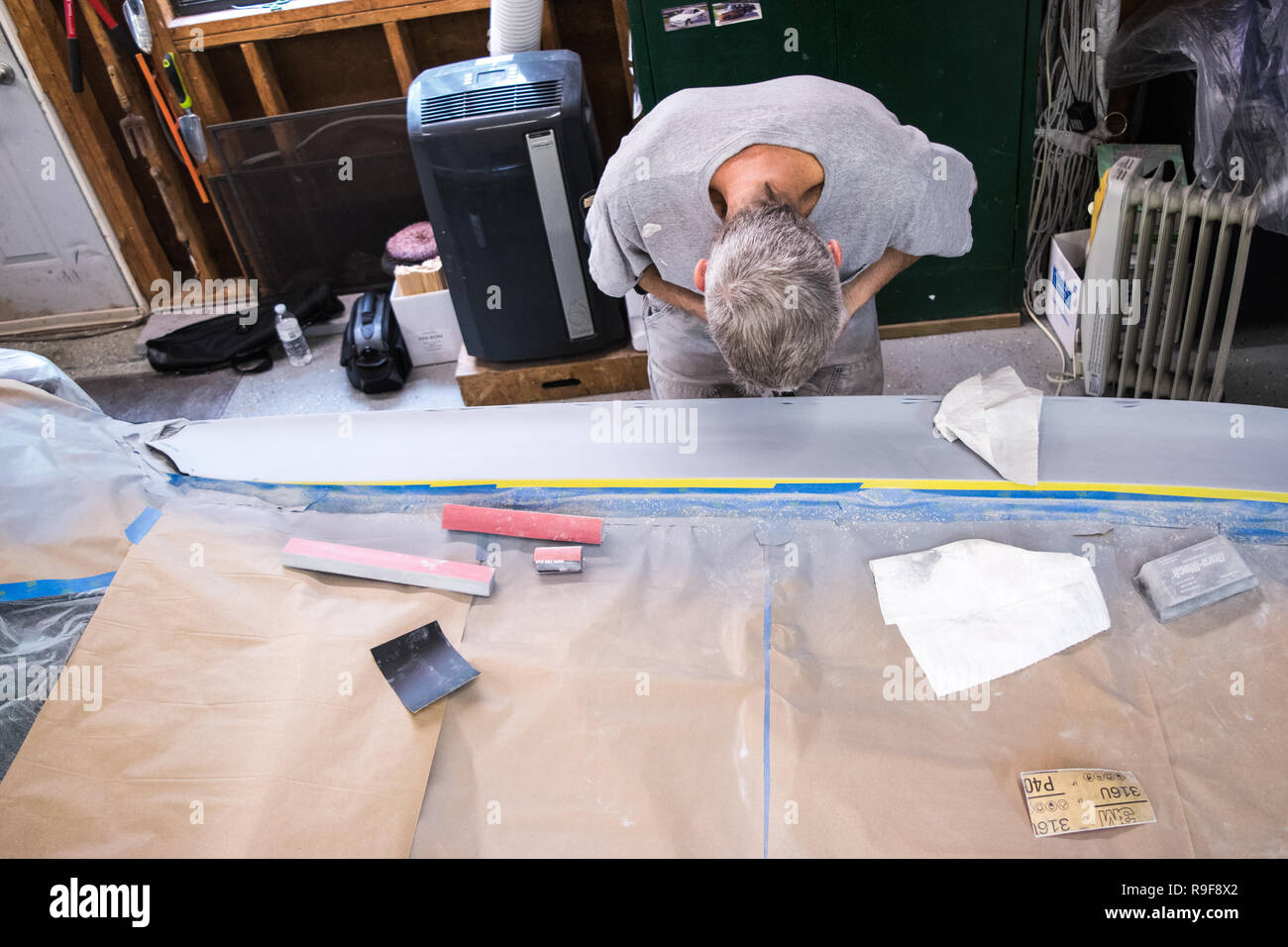 Craftsman showing dedication to his business in classic car bodywork out of garage Stock Photo