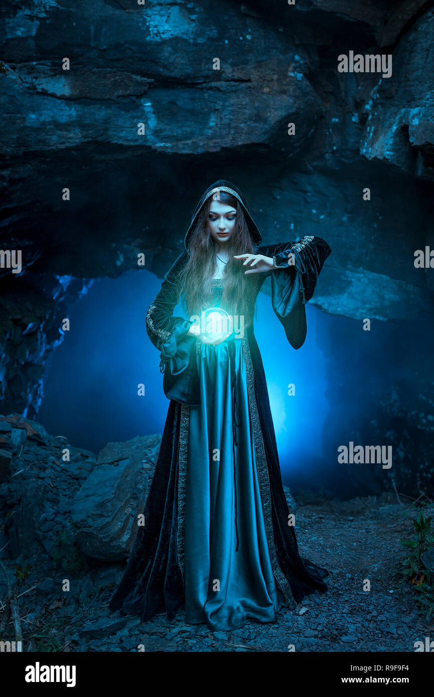 The witch with magic ball in her hands causes a spirits Stock Photo